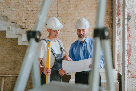 Happy architect having discussion with building contractor at site
