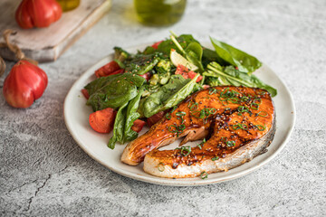 Portion of gourmet grilled salmon steak with vegetables