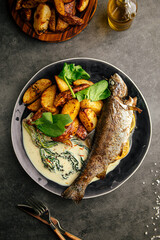 Portion of cooked grilled fish with potato and sauce