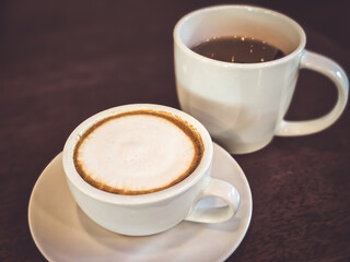 Hot cappuccino coffee in a mug Placed on the table in a warm atmosphere.
