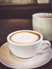 Hot cappuccino coffee in a mug Placed on the table in a warm atmosphere.