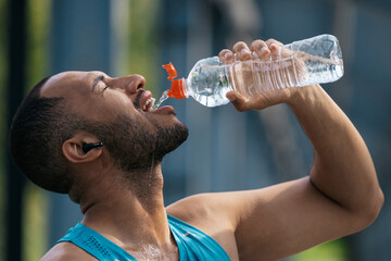 Sportsman feeling thirsty after workout and drinking water - obrazy, fototapety, plakaty