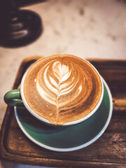 Hot cappuccino coffee in a mug Placed on the table in a warm atmosphere.