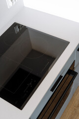 High angle shot of induction stove with control panel and clean surface in kitchen