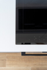 Close up view of black glass induction hob with control panel on white countertop