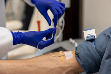 Patient man receiving infusion drip in hospital or beauty salon.