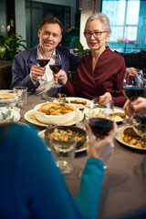 Young man and aged woman in restaurant celebrating new year