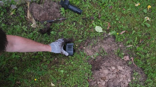 Hands of gardener setting a mole trap, close-up video