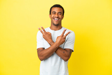 African American handsome man on isolated yellow background smiling and showing victory sign