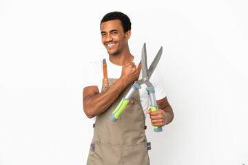 African American gardener man holding pruning shears over isolated white background celebrating a...
