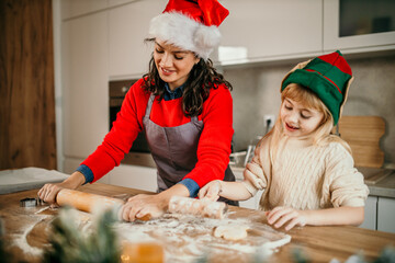 A mother and daughter duo spreading holiday cheer in the kitchen, surrounded by the creative mess