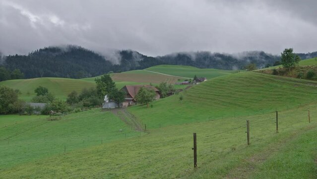 Clouds and fog rolling over a farm in the hills of the Emmental in Switzerland