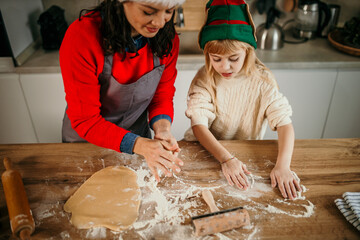 A mother guiding her daughter through the magical process of making Christmas cookies