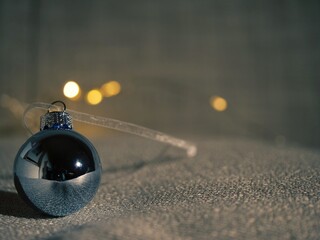 Silver Christmas bauble with golden bokeh lights