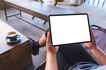 Mockup image of a woman holding digital tablet with blank white desktop screen in cafe