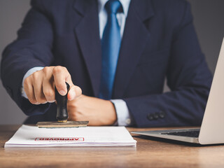 Businessman stamped for approved documents while sitting at a desk