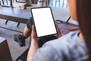 Mockup image of a woman holding digital tablet with blank white desktop screen in cafe