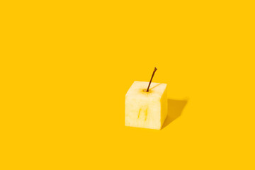 Concept of creativity and innovative ideas. Square apple on yellow background.