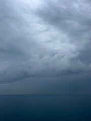 Fototapeta na wymiar Dark rainy clouds at the sea, cloudy seascape, deep blue sea horizon