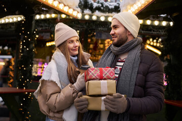 Caucasian couple on Christmas market with Christmas presents