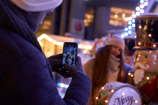 Man taking picture of his female friend during Christmas Market