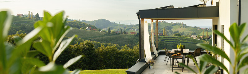 The banner. The terrace of the house offers views of the hills and vineyards. Austria - obrazy, fototapety, plakaty