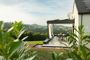 The terrace of the house offers views of the hills and vineyards. Austria - obrazy, fototapety, plakaty