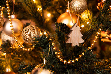 Close-up og wooden christmass tree decoration surrounded by the golden and brown christmass balls...