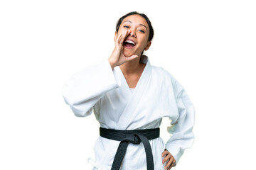 Young Uruguayan woman doing karate over isolated chroma key background shouting with mouth wide open