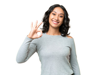 Young Argentinian woman over isolated background showing ok sign with fingers