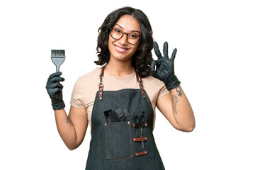 Young argentinian hairdresser woman over isolated background showing ok sign with fingers