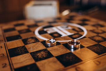 Wedding rings on a chessboard, Krasnodar, Russia. Vertical