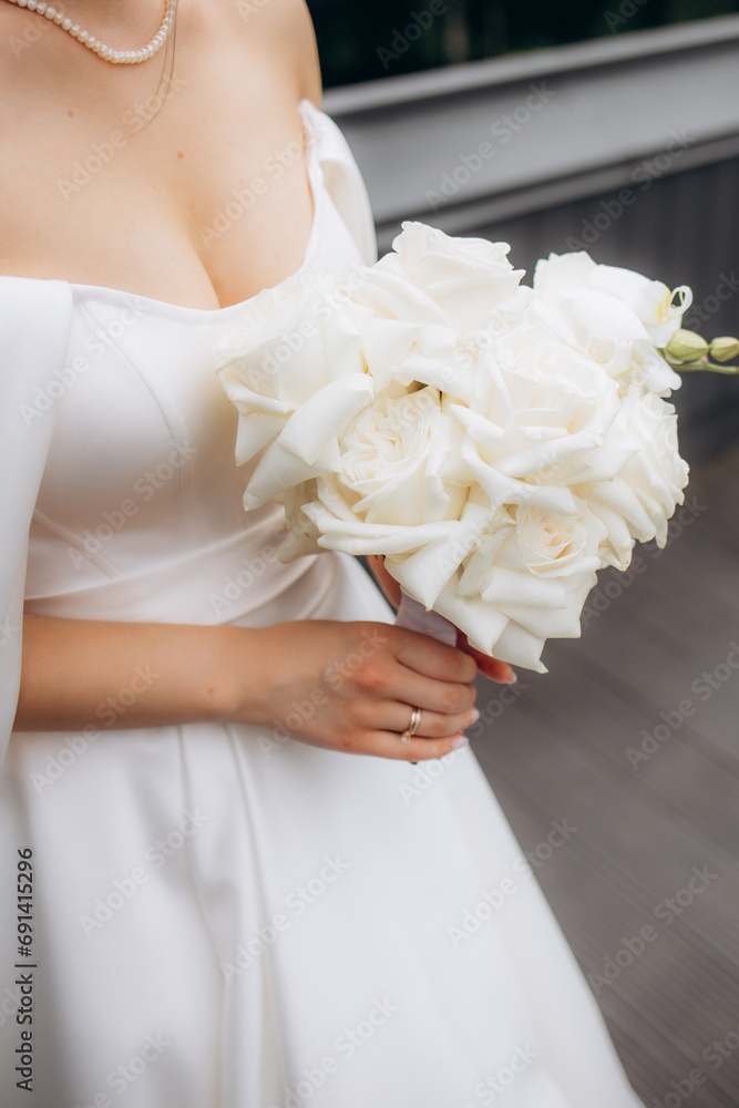 Wall mural Wedding. Details. A bride's bouquet of flowers and greenery lies on a vintage white table, women's shoes stand nearby