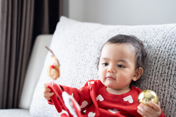 Fototapeta premium A boy wears red for a Christmas theme on sofa, cute boy, Babe.