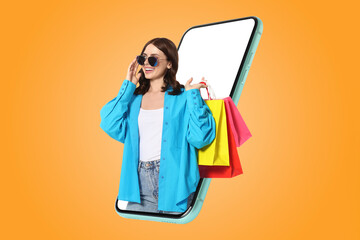Online shopping. Happy woman with paper bags looking out from smartphone on orange background