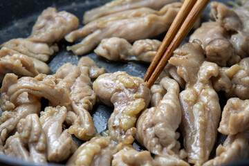 Fototapeta na wymiar 鶏肉(セセリ)をフライパンで炒める調理シーン。 