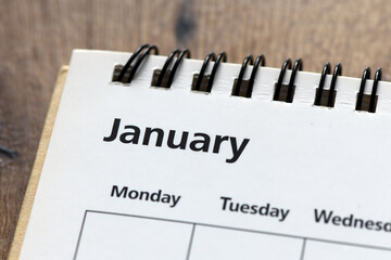 word JANUARY in the calendar on a wooden table.