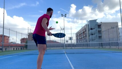 Portrait of a young man playing pickleball. Young man going to perform the serve point in...