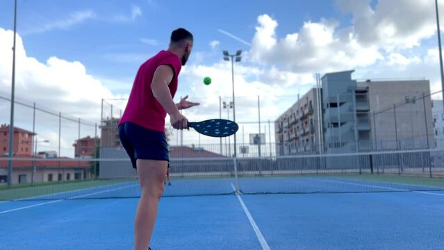 Portrait of a young man playing pickleball. Young man going to perform the serve point in pickleball.
