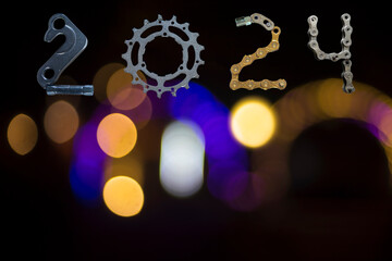 Happy New Year 2024 from bicycles part on blurry light background