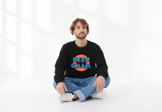 Mockup of man wearing customizable sweatshirt sitting cross legged