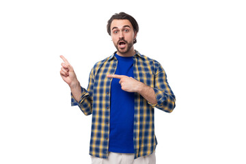 young stylish handsome caucasian brunette with a beard is dressed in a blue plaid shirt and t-shirt