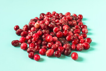 Frozen red cranberry berries on a light background in close-up.