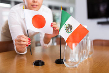 Secretary shows the flags of Mexico and Japan on the table. Preparing for a meeting, negotiations.