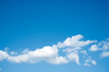 Horizontal white clouds on clear blu sky background with top copy space