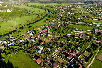 Landscape of picturesque countryside from the air, a village located along a river bed