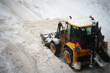 Tractor shoveling snow on the street.