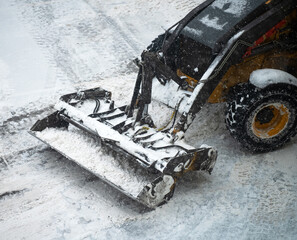Tractor shoveling snow on the street.
