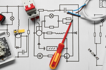 Different electrician's equipment and screwdriver on wiring diagram, flat lay
