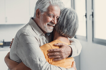 Happy mature couple in love embracing, laughing grey haired husband and wife with closed eyes,...